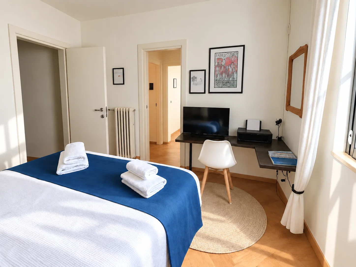 Bedroom with desk, TV and door to the hallway